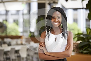 Smiling young black businesswoman with arms crossed