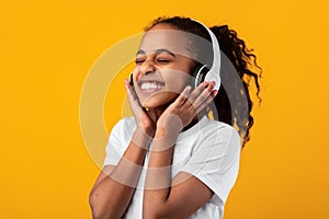 Smiling Young Black Girl Listening To Music In Headset