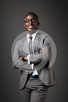 Smiling young black man with glasses and gray business suit