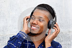 Smiling young black man with headphones listening to music