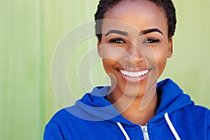 Smiling young black woman against green background