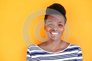 Smiling young black woman against yellow background