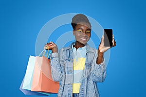 Smiling young black woman shopping online, using mobile app