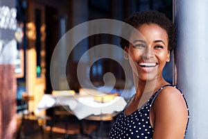 Smiling young black woman standing outside