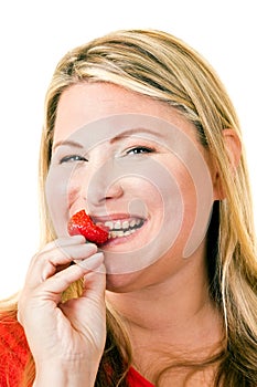 Smiling young blond woman with ripe strawberry
