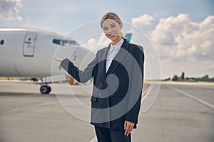 Cheerful Caucasian woman pointing at the plane