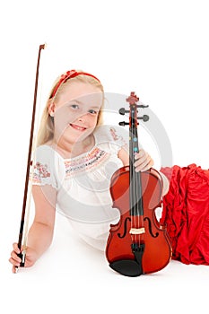 Smiling young blonde girl poses with violin on a white studio background