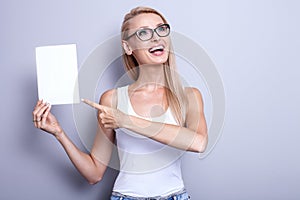 Smiling young blonde woman with empty card.