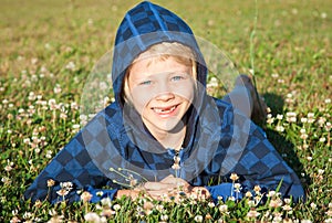 Smiling young boy lying in grass smiling