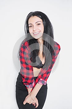 Smiling young brunette posing in a plaid shirt