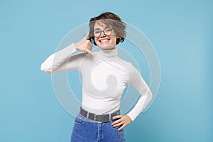 Smiling young brunette woman girl in casual white clothes, glasses posing isolated on pastel blue background. People