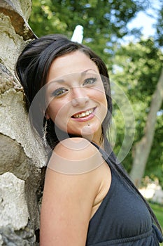 Smiling young brunette woman posing outdoors