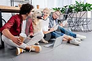 smiling young business colleagues looking at dog while working together