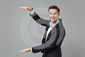 Smiling young business man in classic suit shirt isolated on grey wall background. Achievement career wealth business