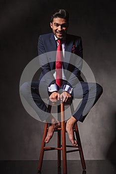 Smiling young business man sitting on a chair