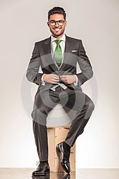 Smiling young business man sitting on wood boxes