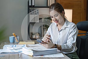 Smiling young business woman, happy beautiful professional lady worker holding smartphone using cellphone mobile working