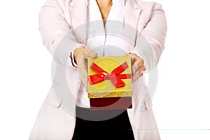 Smiling young business woman holding present box