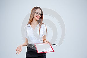 The smiling young business woman with pen and tablet for notes on gray background