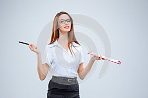 The smiling young business woman with pen and tablet for notes on gray background