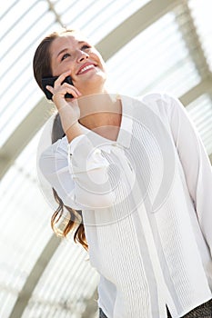 Smiling young business woman talking on cell phone