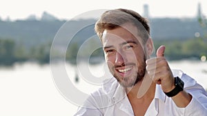 Smiling young businessman giving thumbs up