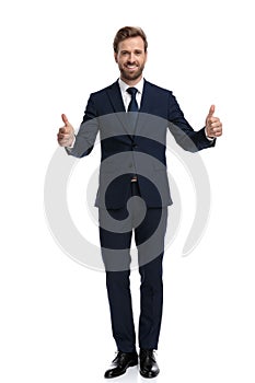 Smiling young businessman making thumbs up sign