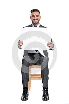 Smiling young businessman presenting speech bubble