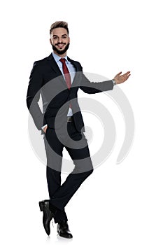 Smiling young businessman presenting to side