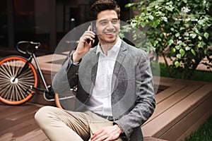 Smiling young businessman talking on moible phone