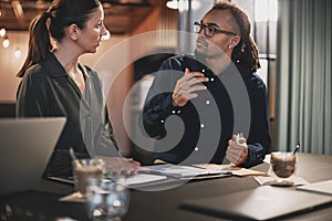 Smiling young businesspeople working at a table in an office