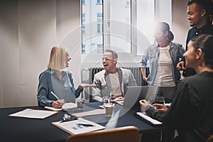 Smiling young businesspeople working at a table in an office