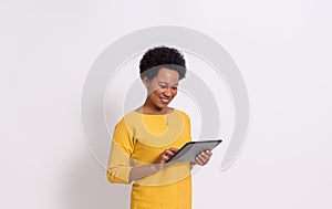 Smiling young businesswoman with afro hairstyle working over digital tablet on white background