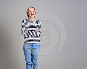 Smiling young businesswoman with arms crossed contemplating and looking away on white background