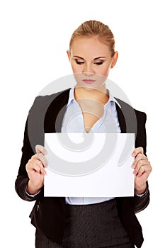 Smiling young businesswoman holding blank banner