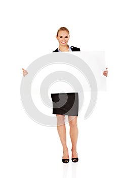 Smiling young businesswoman holding blank banner