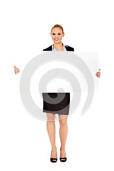 Smiling young businesswoman holding blank banner