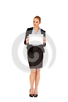 Smiling young businesswoman holding blank banner