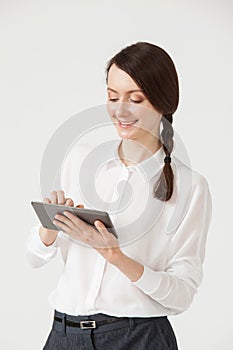 Smiling young businesswoman holding a pad and showing thumb up s