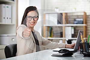 Smiling Young Businesswoman Showing Thumbs Up