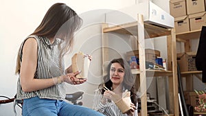 Smiling young businesswomen having lunch at table in office