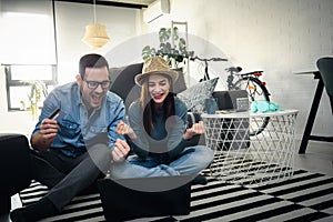 Smiling young Caucasian couple shopping online at home using a laptop with a credit card