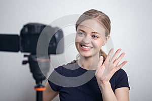 Smiling young caucasian girl woman making a video blog vlog with camera
