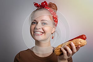 Smiling young Caucasian woman girl holding eating big size hot dog bun. Unhealthy fast food concept