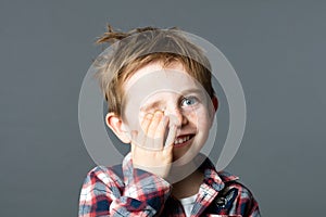 Smiling young child hiding one eye for joyous hide-and-seek