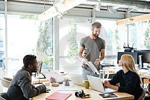 Smiling young colleagues sitting in office coworking photo