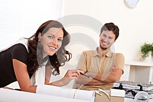 Smiling young couple with architectural model