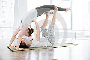 Smiling young couple doing acrobatic yoga position