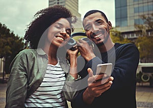 Smiling young couple enjoying listening to music on one headphone