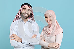 Smiling young couple friends arabian muslim man wonam in keffiyeh kafiya ring igal agal hijab clothes isolated on blue